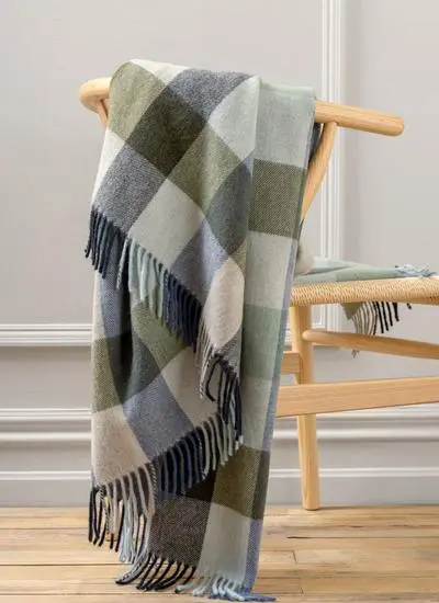 Blue and green check lambswool throw draped across wooden chair